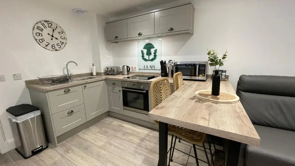 a kitchen with a table and a counter top at The Forge by Caithness Luxury Apartments NC500 - Elegant Luxury Apartment with Bike store - Sleeps 4 in Wick