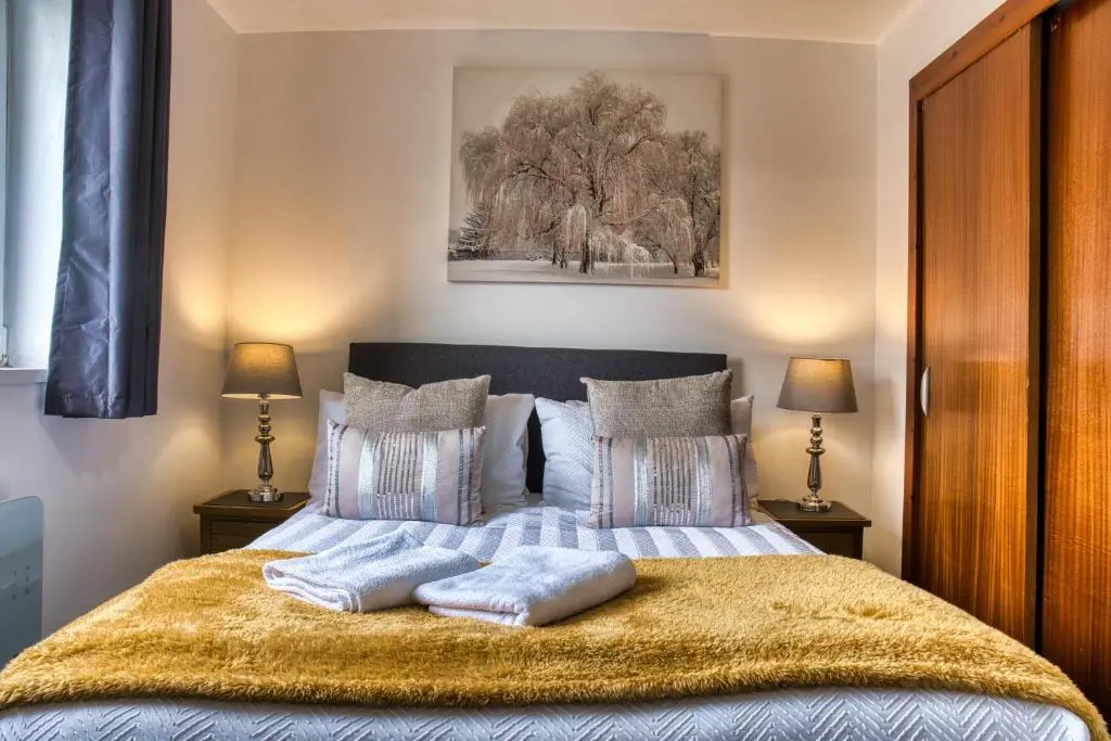 a bedroom with a bed with two pillows on it at Two Bed Holiday Home with Free Parking in Inverness in Inverness