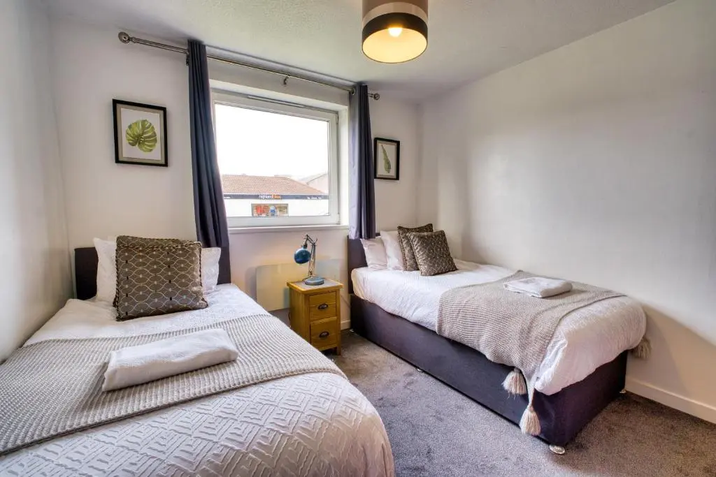 a bedroom with two beds and a window at Two Bed Holiday Home with Free Parking in Inverness in Inverness