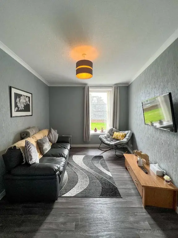 a living room with a couch and a table at Helens Lybster cosy cottage on NC500 in Lybster