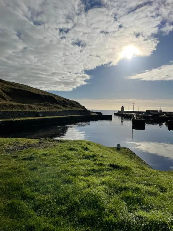 a body of water with the sun in the sky at Helens Lybster cosy cottage on NC500 in Lybster