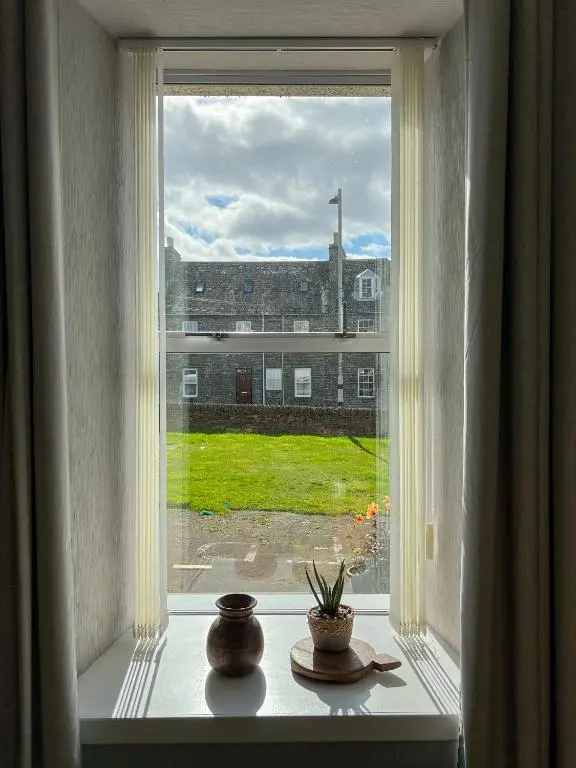 a window with a view of a building at Helens Lybster cosy cottage on NC500 in Lybster