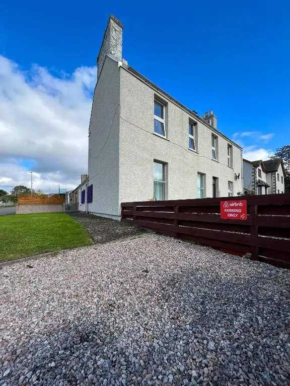 a building with a fence in front of it at Helens Lybster cosy cottage on NC500 in Lybster