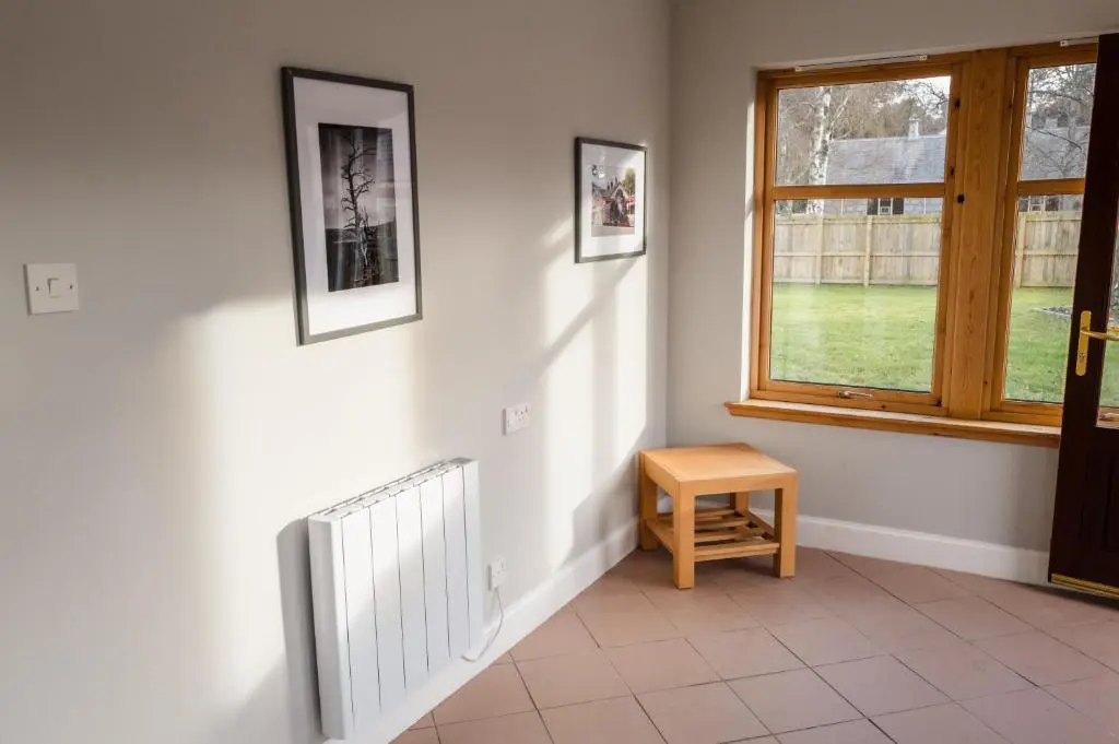 a hallway with a window and a table and a radiator at Anne's Place in Boat of Garten
