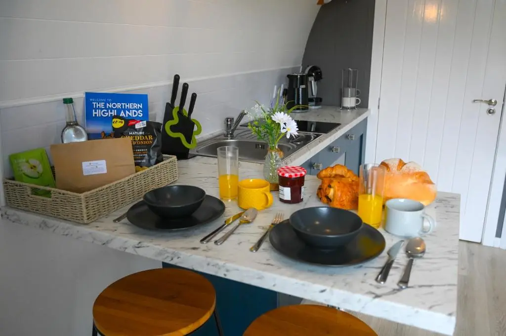 a kitchen counter with two black bowls and utensils at Newmore Highland Pods with Hot Tubs on NC500 in Invergordon