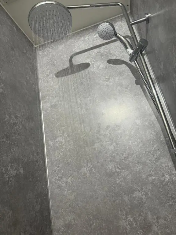 a shower with a shower head with a microphone at Stephen's Street Apartment, Inverness City Centre in Inverness