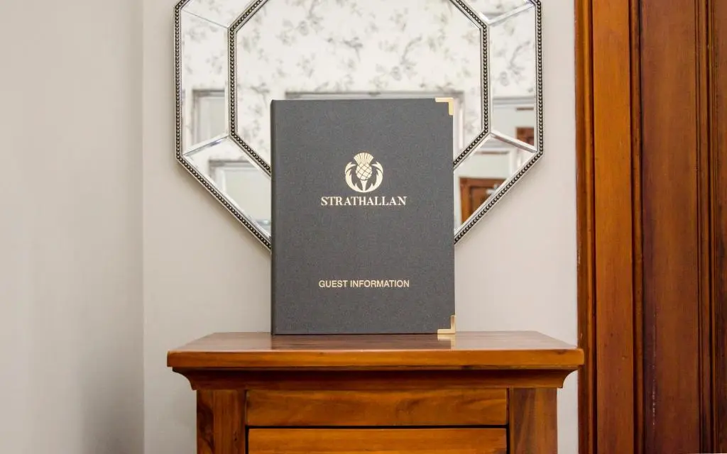 a book sitting on a table in front of a mirror at Strathallan Bed and Breakfast in Grantown on Spey