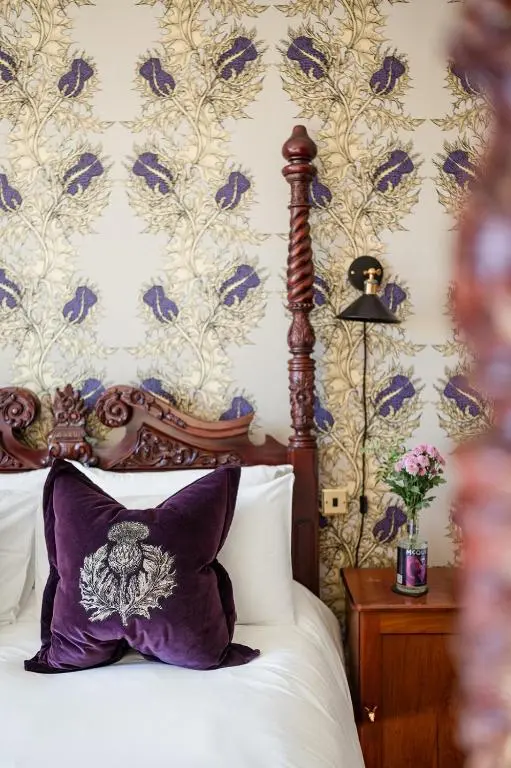a bedroom with a bed with a purple pillow and a wallpaper at Strathallan Bed and Breakfast in Grantown on Spey