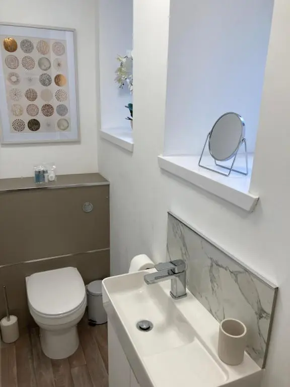 a bathroom with a toilet and a sink and a mirror at Haugh Ness in Inverness