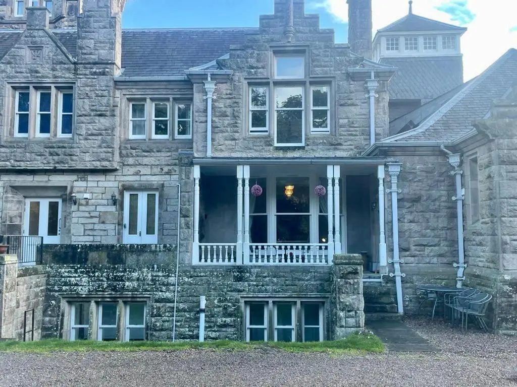 a stone house with a porch and a balcony at Serviced Accommodation Moray - Lesmurdie House No 2 in Elgin