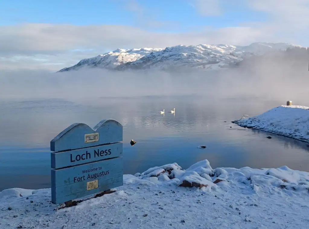 a sign in the snow next to a body of water at Erraid Lodge in Fort Augustus