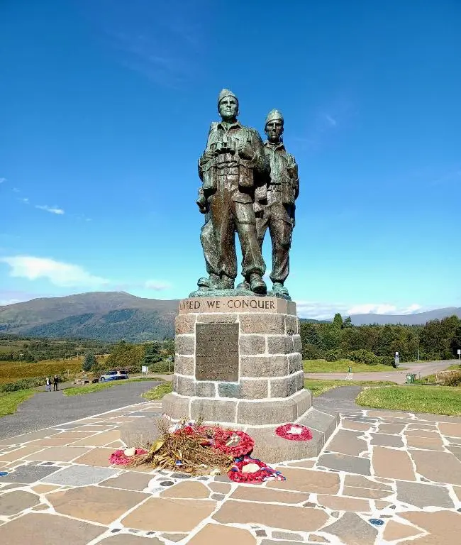 a statue of two firefighters standing on top of a monument at Erraid Lodge in Fort Augustus