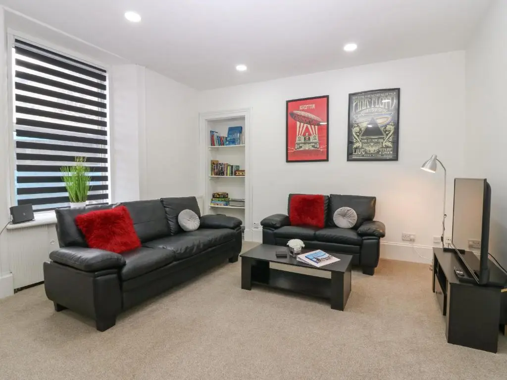 a living room with two couches and a table at RockStar Cottage in Macduff