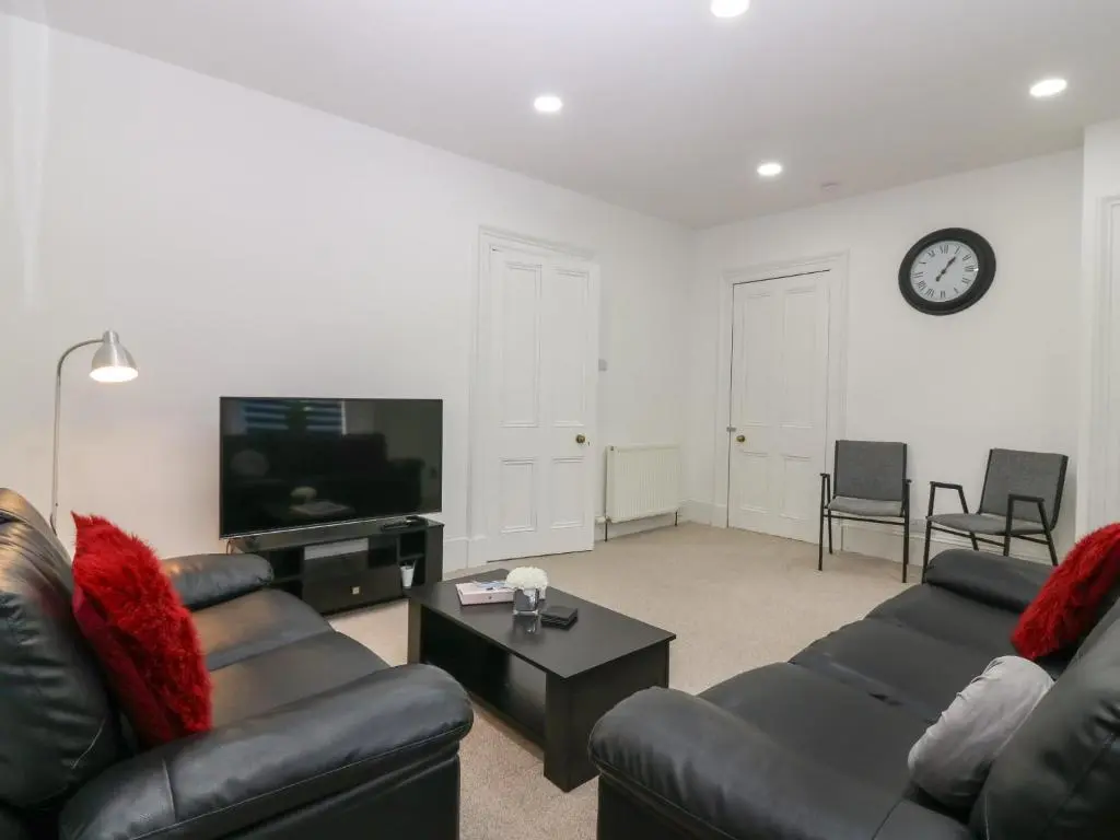 a living room with two couches and a tv at RockStar Cottage in Macduff