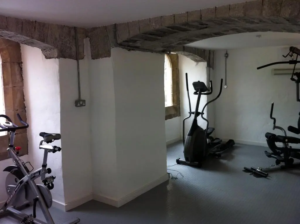 a gym with bikes and exercise equipment in a room at Raven Wing Apartments - Highland Club Scotland in Fort Augustus