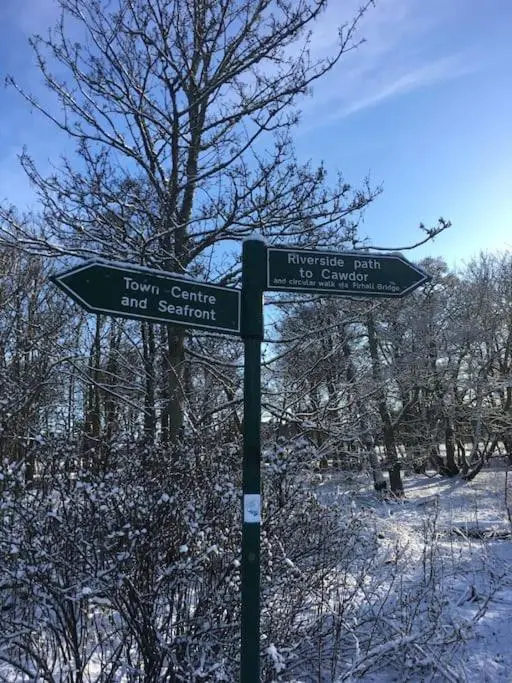 a street sign on a pole in the snow at Kings Cottage, Nairn - a charming place to stay in Nairn