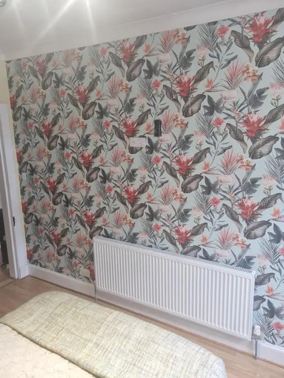 a nursery with a bird wallpaper on the wall at Nanny Bambi's highland hoose in Inverness