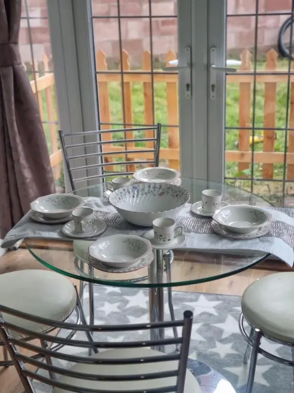 a glass table with bowls and cups on it at Nanny Bambi's highland hoose in Inverness
