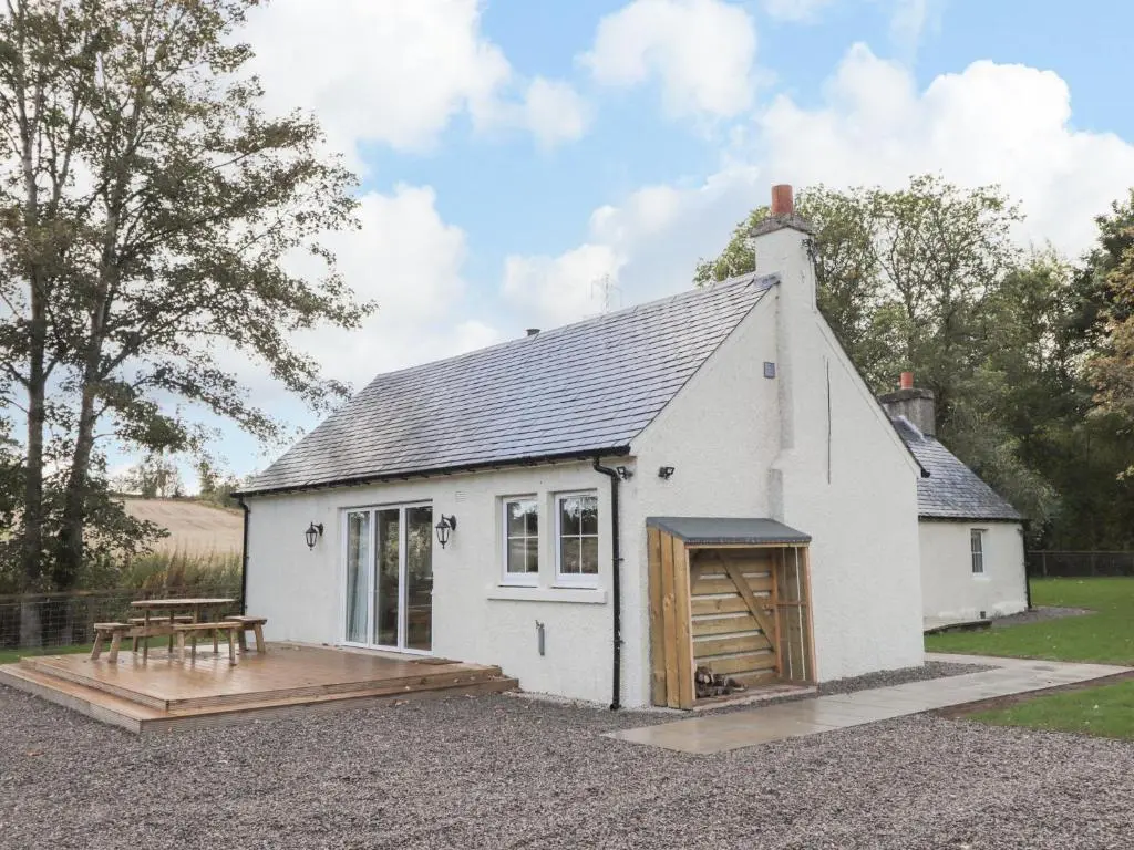 a small white building with a picnic table in front of it at Bonnach in Muir of Ord