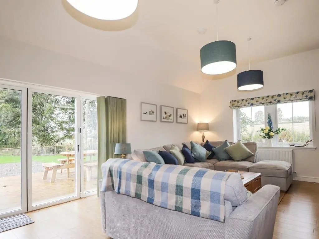 a living room with a couch and a table at Bonnach in Muir of Ord