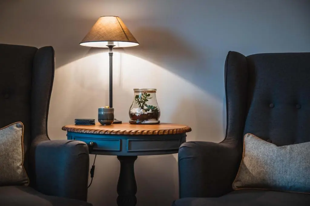 a table with a lamp on it next to two chairs at Drumdry in Wick