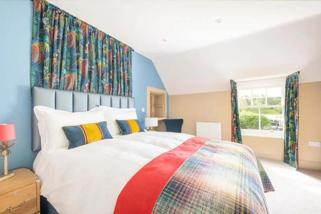 a bedroom with a large bed with a colorful headboard at Lock Keepers Cottage, Loch Ness Cottage Collection in Inverness