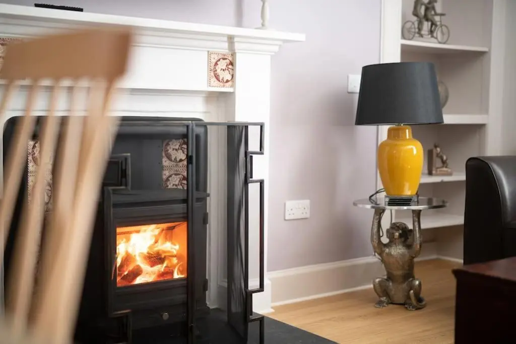 a fireplace in a living room with a fire in it at Lock Keepers Cottage, Loch Ness Cottage Collection in Inverness