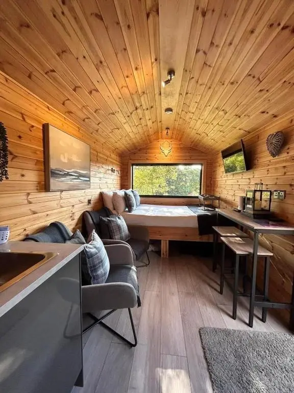 a living room with a couch and a table at River Huts with Private Hot Tubs in Inverness