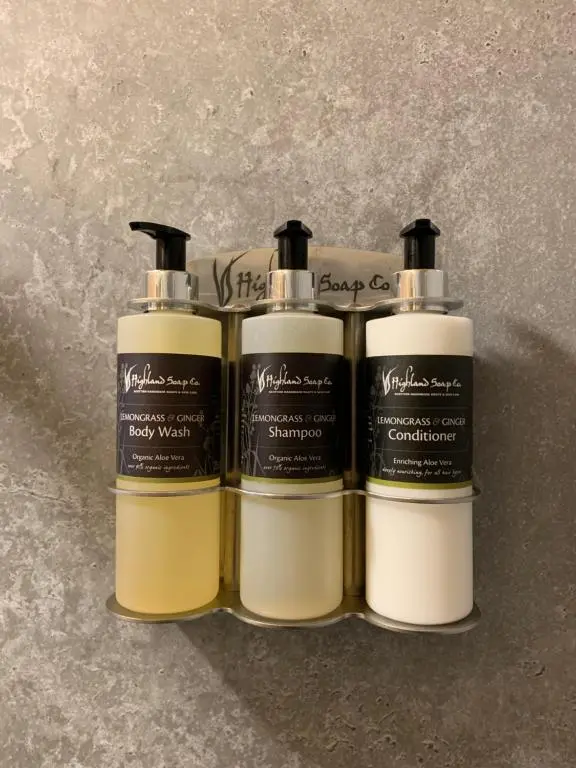 a group of three shampoo bottles sitting on a counter at River Huts with Private Hot Tubs in Inverness