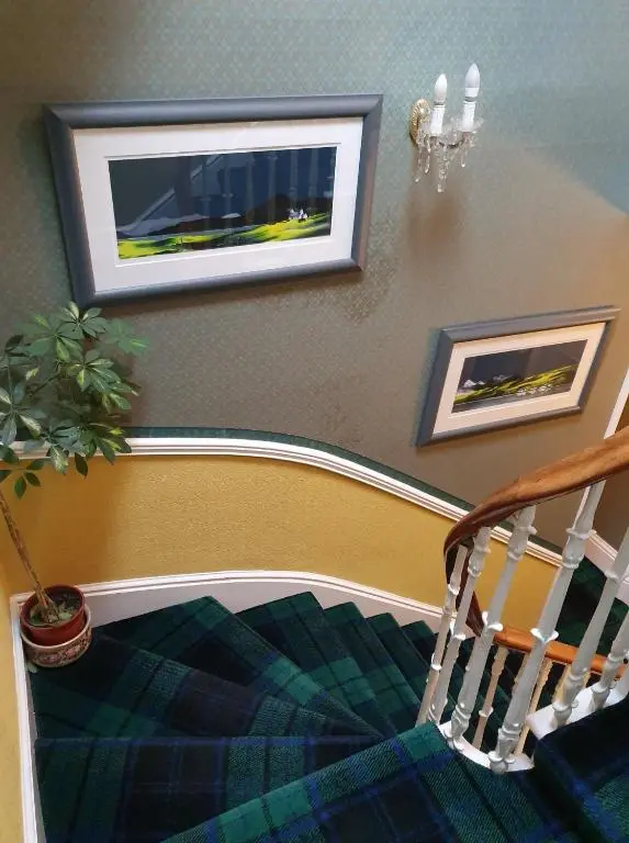 a room with a staircase with a potted plant at Moyness House in Inverness
