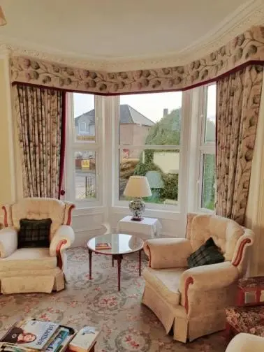 a living room with two chairs and a large window at Moyness House in Inverness
