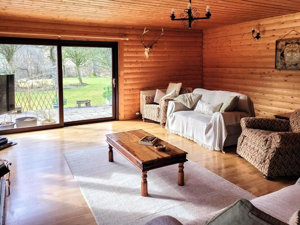 a living room with a couch and a coffee table at Ardle Lodge in Enochdhu