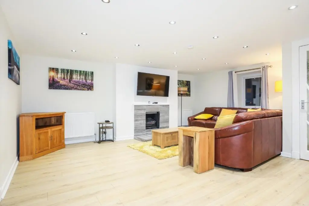 a living room with a couch and a fireplace at mySTAYINN Tomnahurich Guest House in Inverness