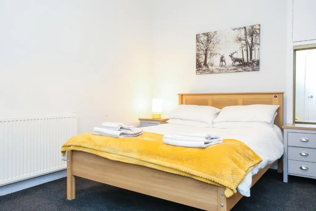 a bedroom with a bed with towels on it at mySTAYINN Tomnahurich Guest House in Inverness