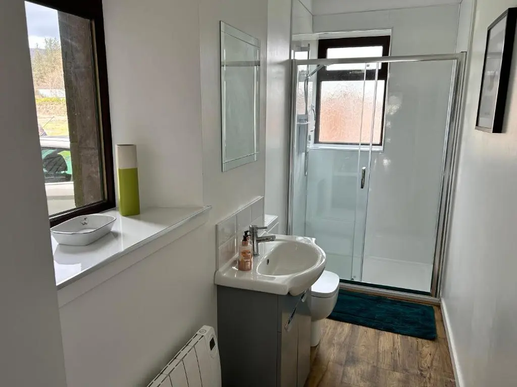 a white bathroom with a sink and a shower at Lottie\u2019s Cottage, Rhynie, Aberdeenshire in Rhynie