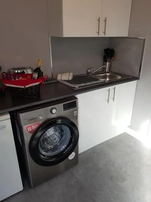 a kitchen with a washing machine and a sink at Craigellachie Cabin in Aviemore