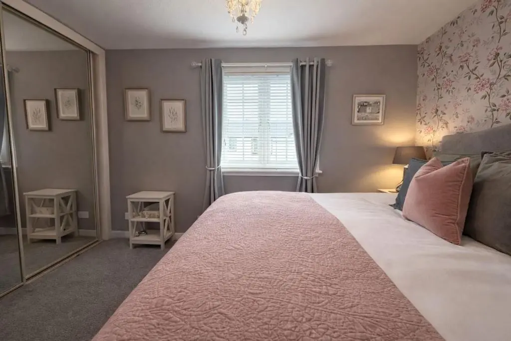 a bedroom with a large bed and a mirror at Apartment No16 in Inverness