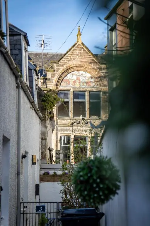 an old building with an archway on a street at Thistle do Nessly in Inverness