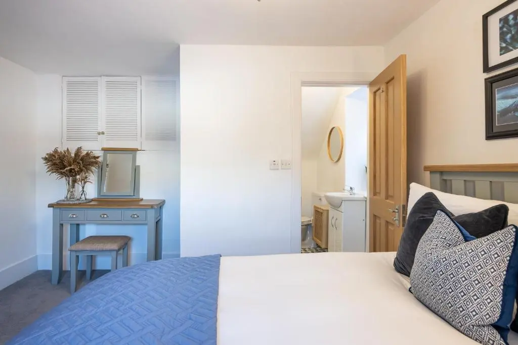 a bedroom with a bed and a table and a chair at Hill Street Haven in Inverness