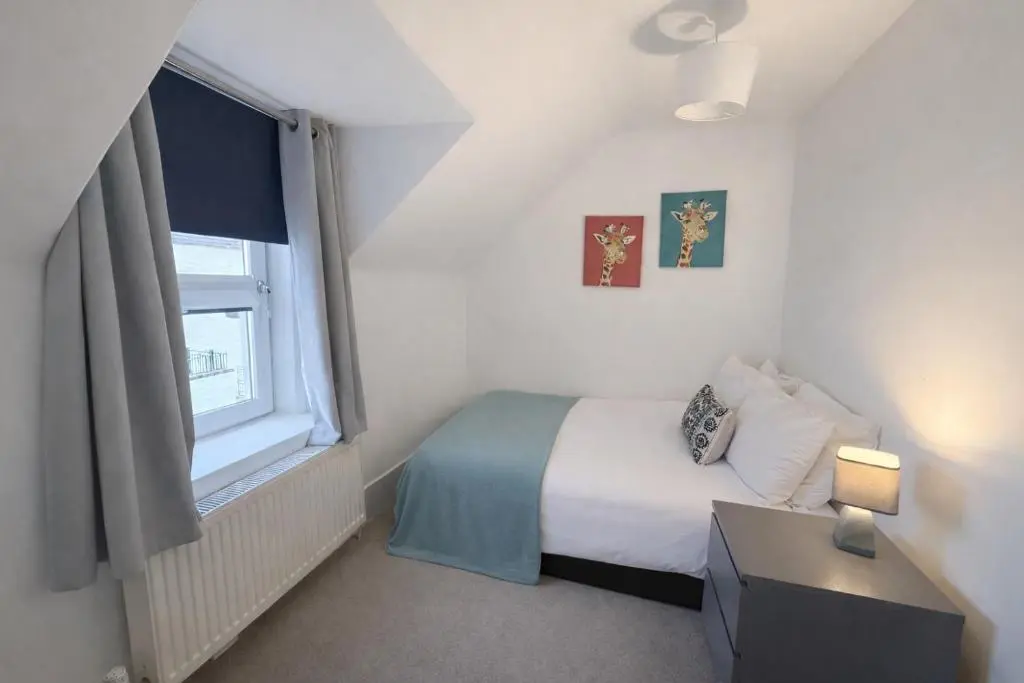a small bedroom with a bed and a window at Hill Street Haven in Inverness