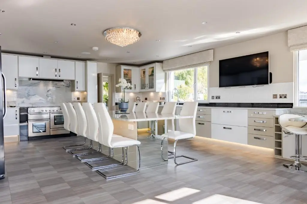 a kitchen with a dining table and white chairs at Fern View in Inverness
