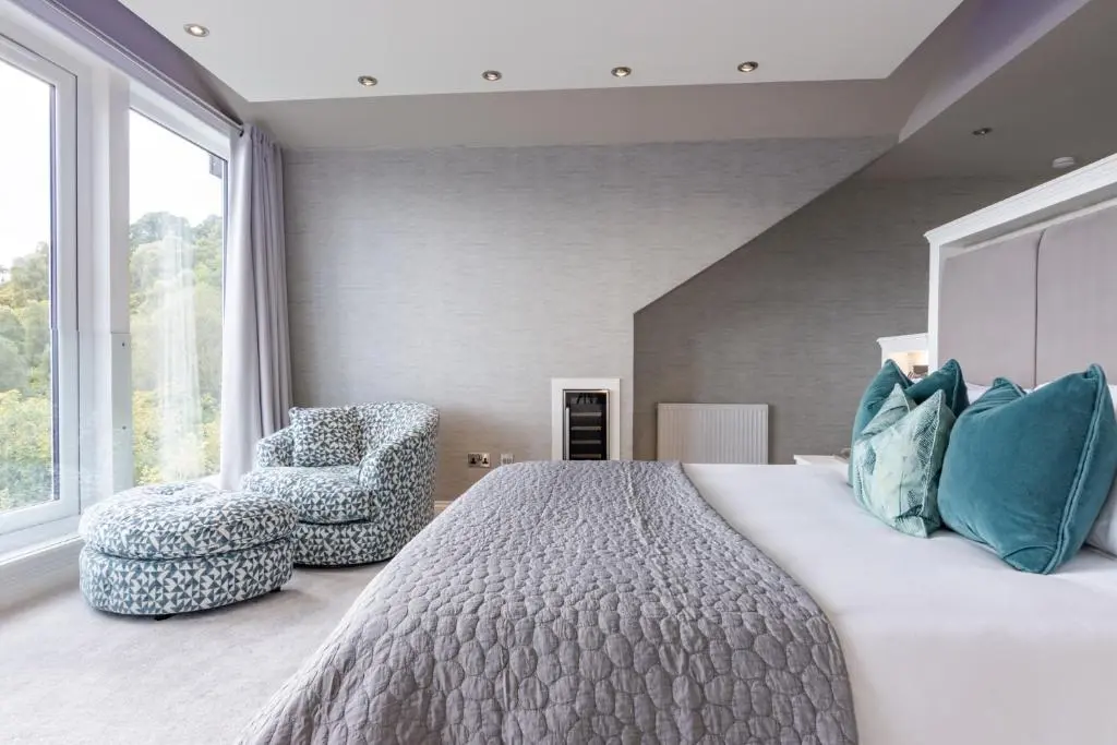 a bedroom with a large bed and a chair at Fern View in Inverness