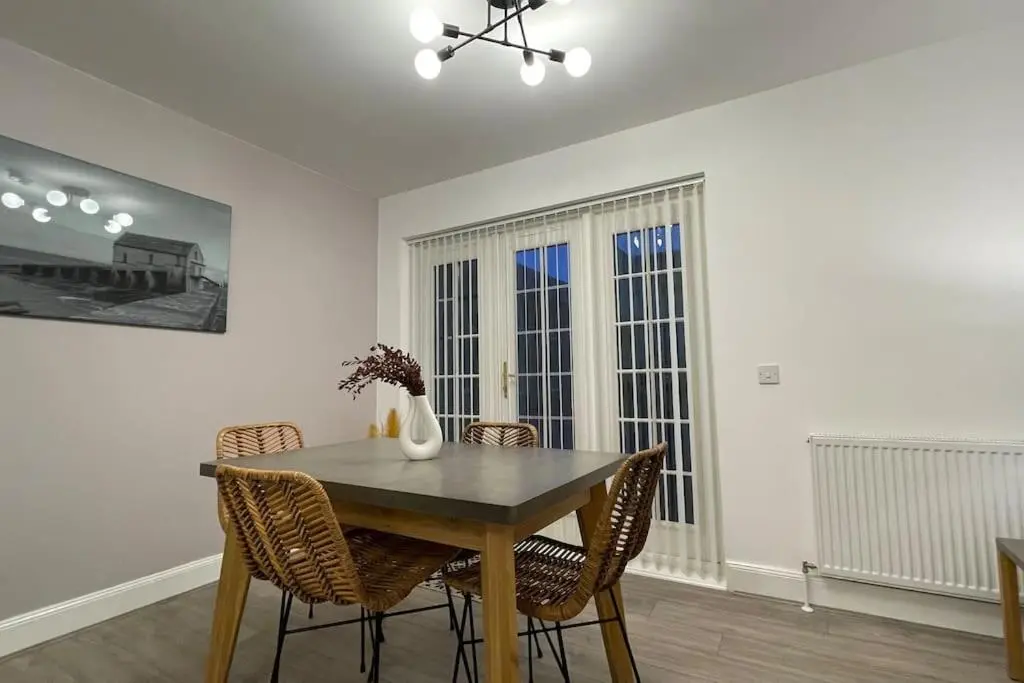 a dining room with a wooden table and chairs at Harbourside by Caithness Luxury Apartments NC500 - 2 Bedroom holiday home - Sleeps Work teams upto 2 & holiday makers upto 6 with bike store in Wick