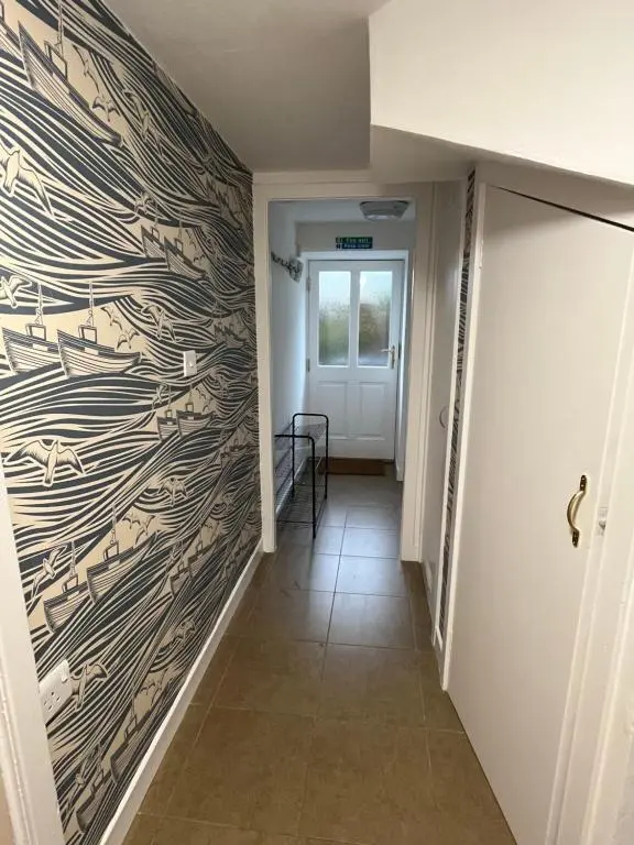 a hallway with a wooden wall with a door at North Coast Property - 17 Margaret Street - Avoch in Avoch