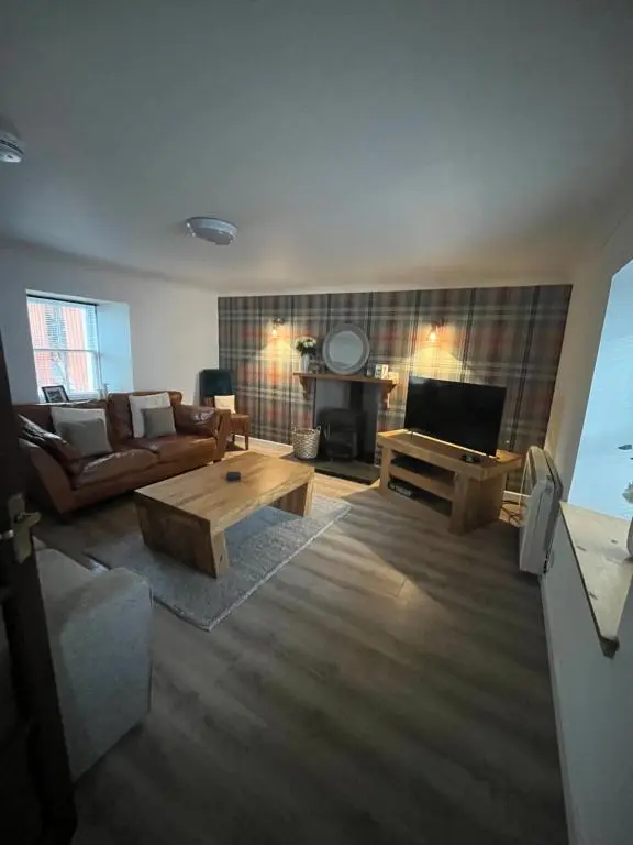 a living room with a couch and a tv at North Coast Property - 17 Margaret Street - Avoch in Avoch