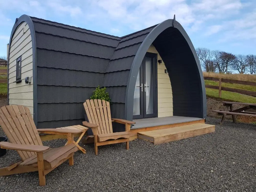 a tiny house with two chairs and a table at Dunbeath Coastal Retreat in Dunbeath
