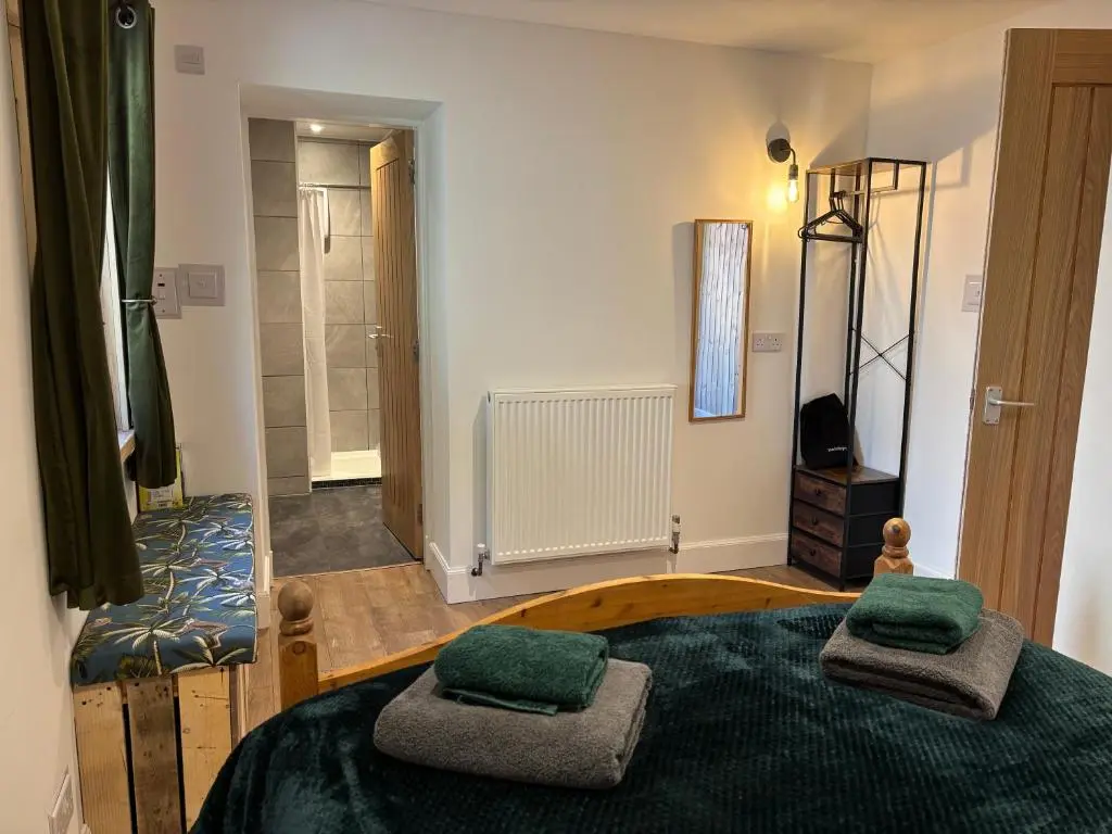 a bedroom with a bed with two green pillows on it at Ardenbeg in Grantown on Spey