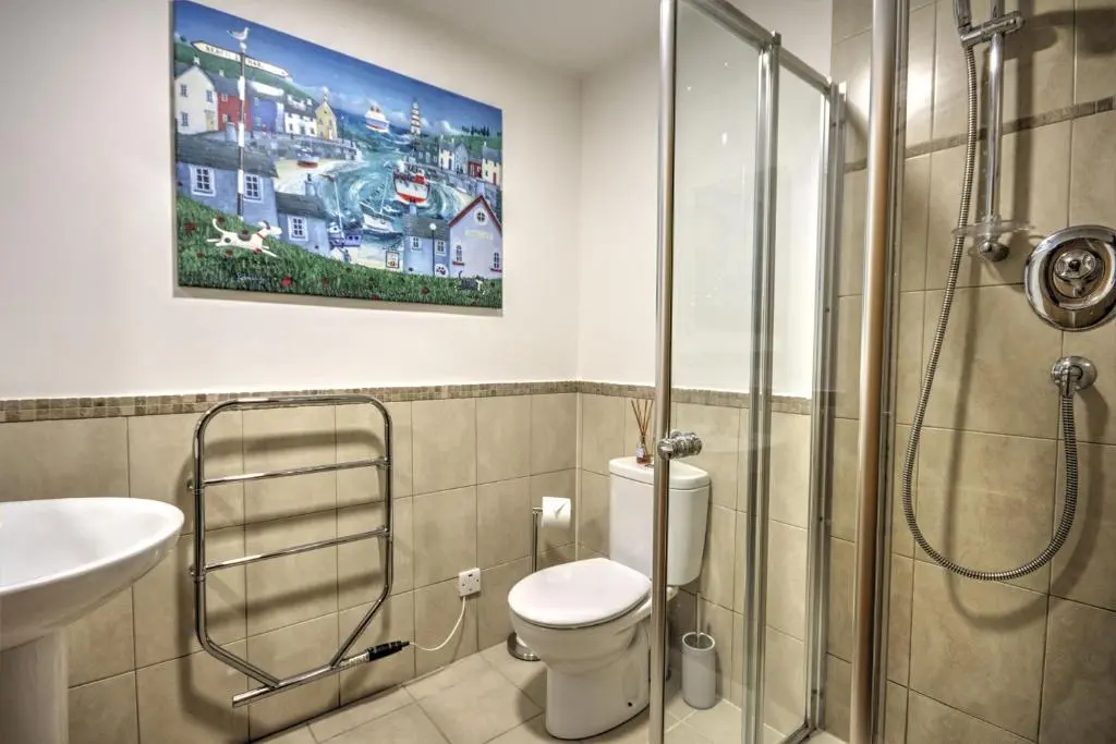 a bathroom with a shower and a toilet and a sink at 5 Argyle Place, Dornoch in Dornoch