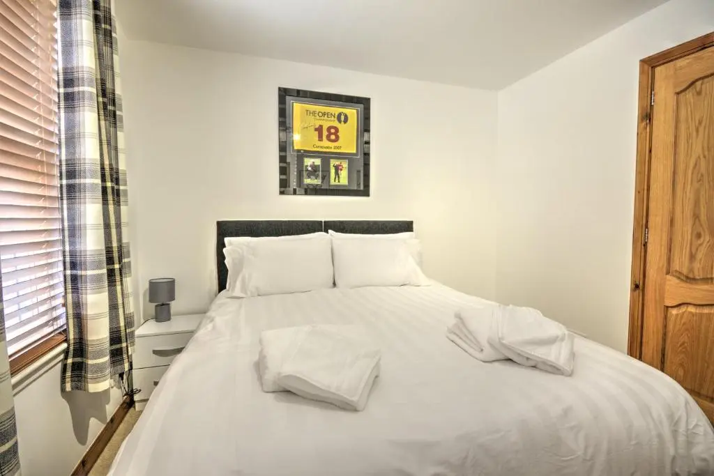 a bedroom with a white bed with two white pillows at 5 Argyle Place, Dornoch in Dornoch