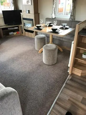 a living room with a table and a couch at Summer Breeze in Aviemore